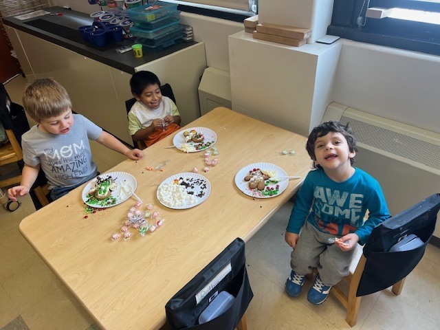 students sitting at tables working on gingerbread people