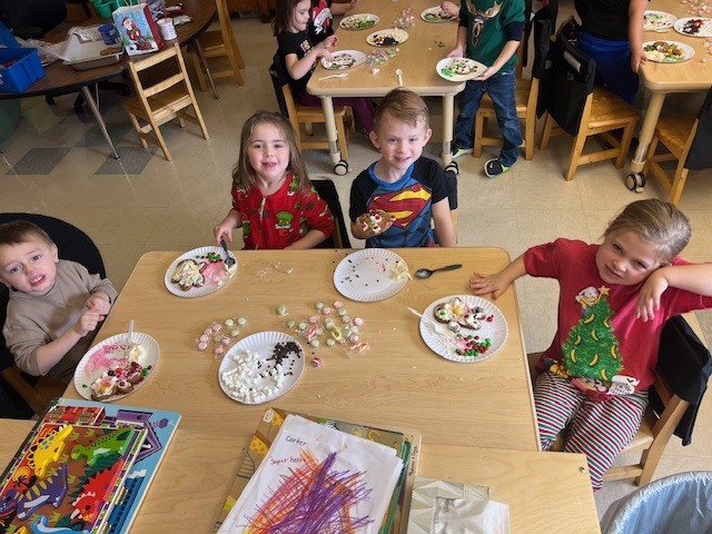students sitting at tables working on gingerbread people