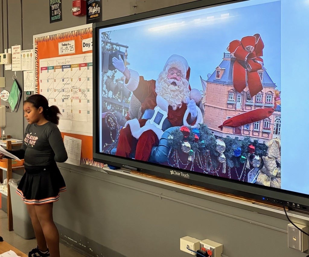 girl speaking in front of smartboard