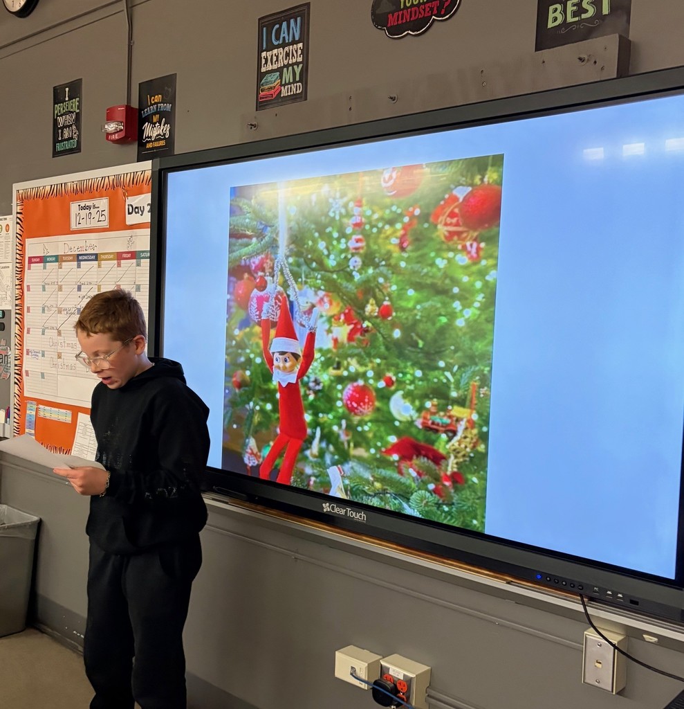 boy speaking in front of smartboard