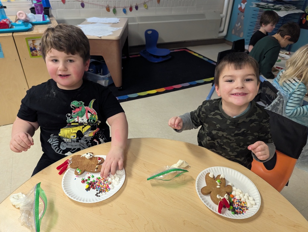 two students decorating gingerbread cookies