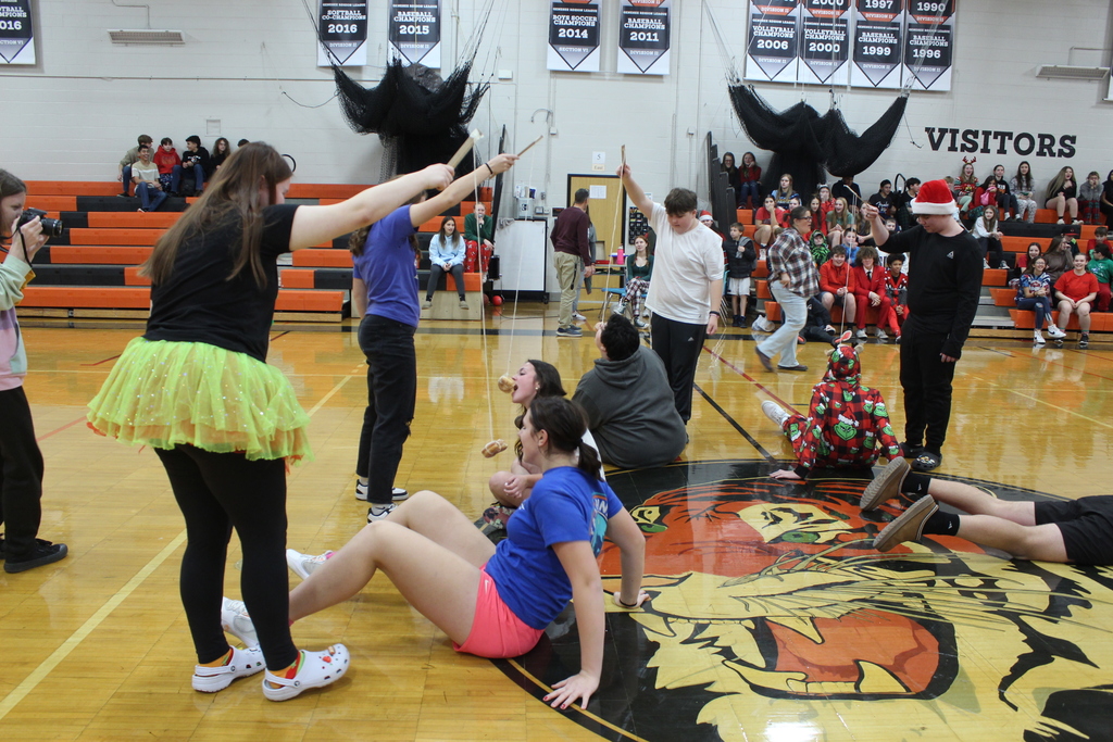 students eating a donut off a string suspended in the air by another student
