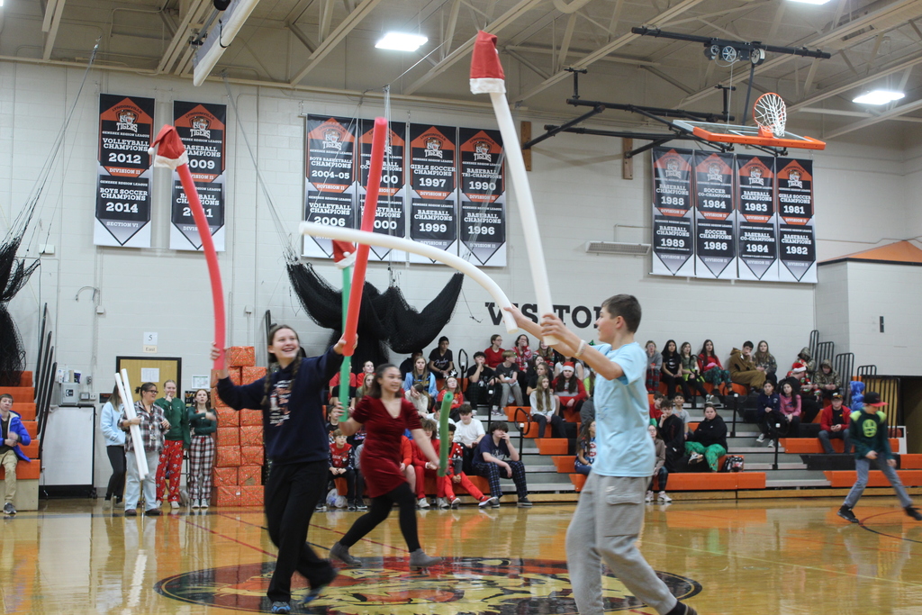 students knocking santa hats off pool noodles