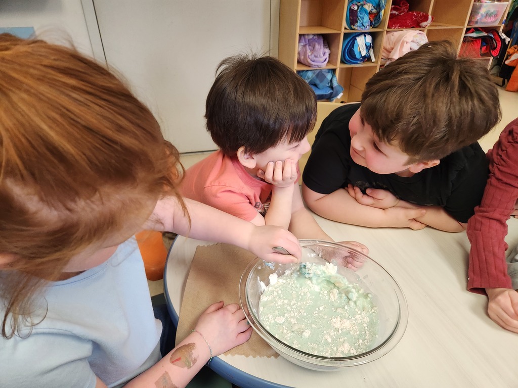 students sitting at table with a bowl of liquid