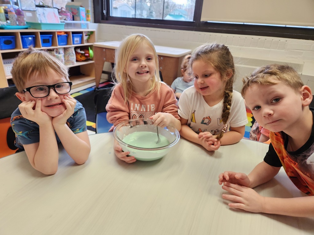 students sitting at table with a bowl of liquid