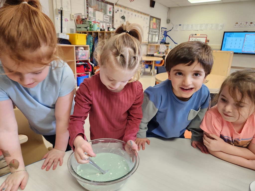 students sitting at table with a bowl of liquid