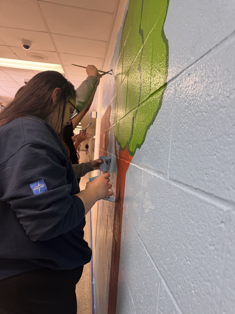 students painting a mural on the wall
