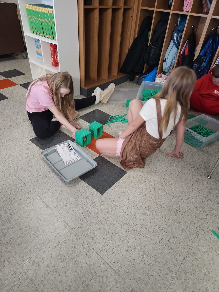 two students working together on the floor