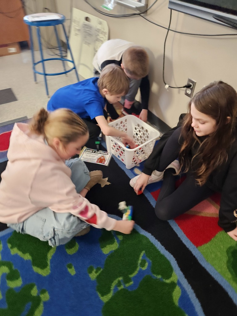 four students working together on the floor