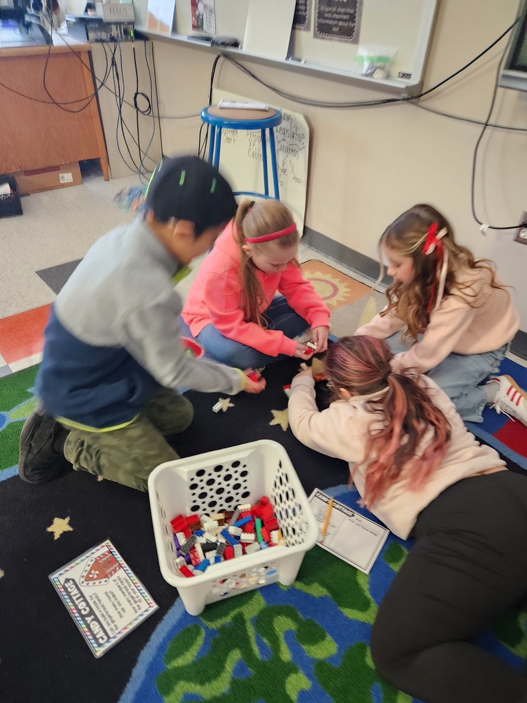 four students working together on the floor