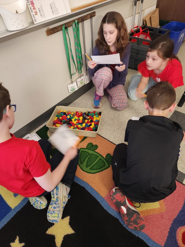 four students working together on the floor