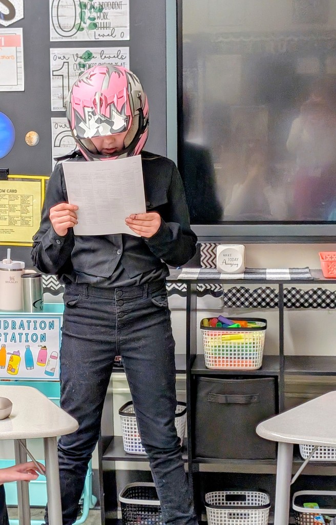 boy wearing helmet reading document