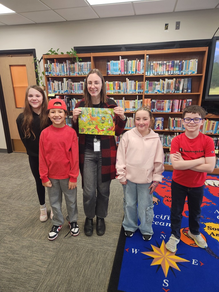 four students and adult holding puzzle in library