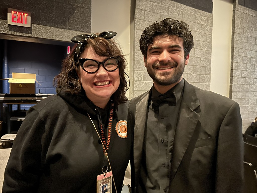 teacher standing next to adult musician
