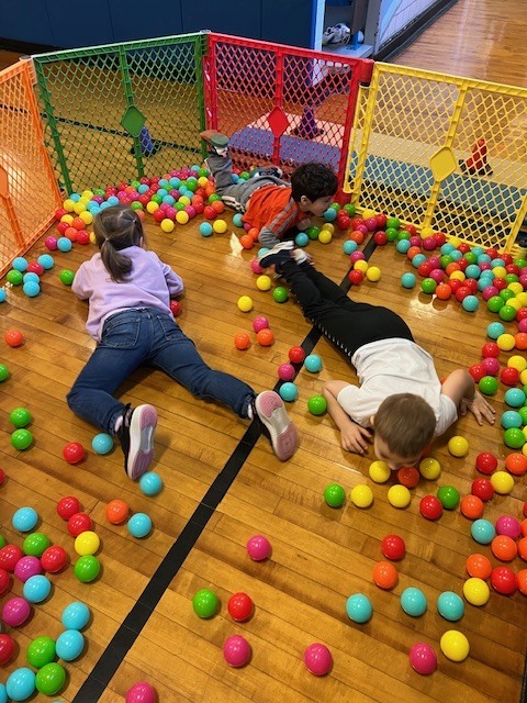 students lying on floor trying to grab balls