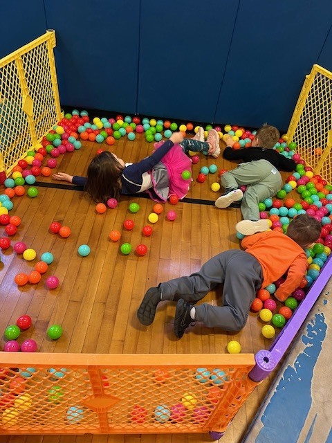 students lying on floor trying to grab balls