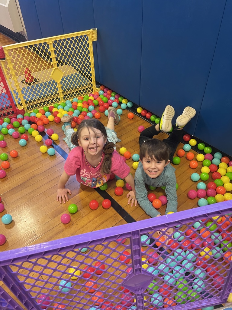 students lying on floor trying to grab balls
