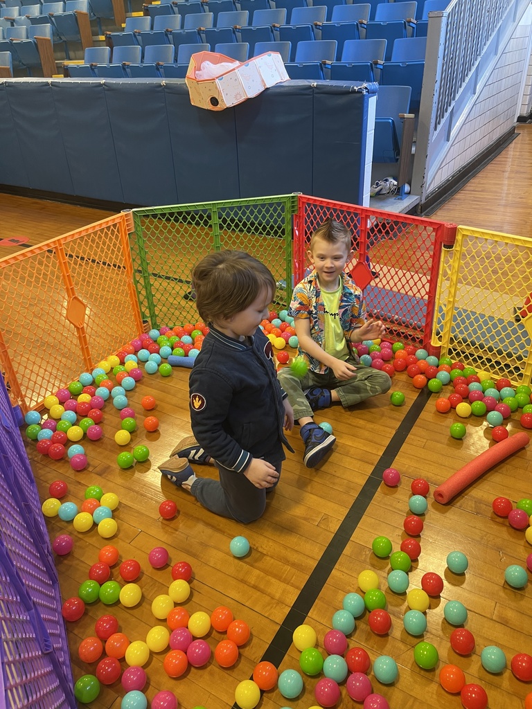 students sitting on floor trying to grab balls