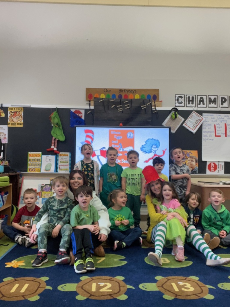 students wearing green in classroom with teacher