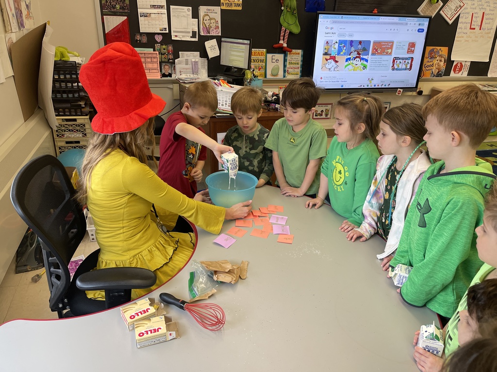 student mixing food in bowl while teacher and students watch