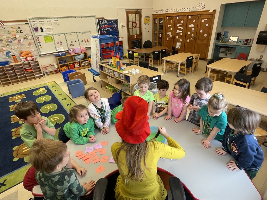 students watch while teacher mixes food in bowl
