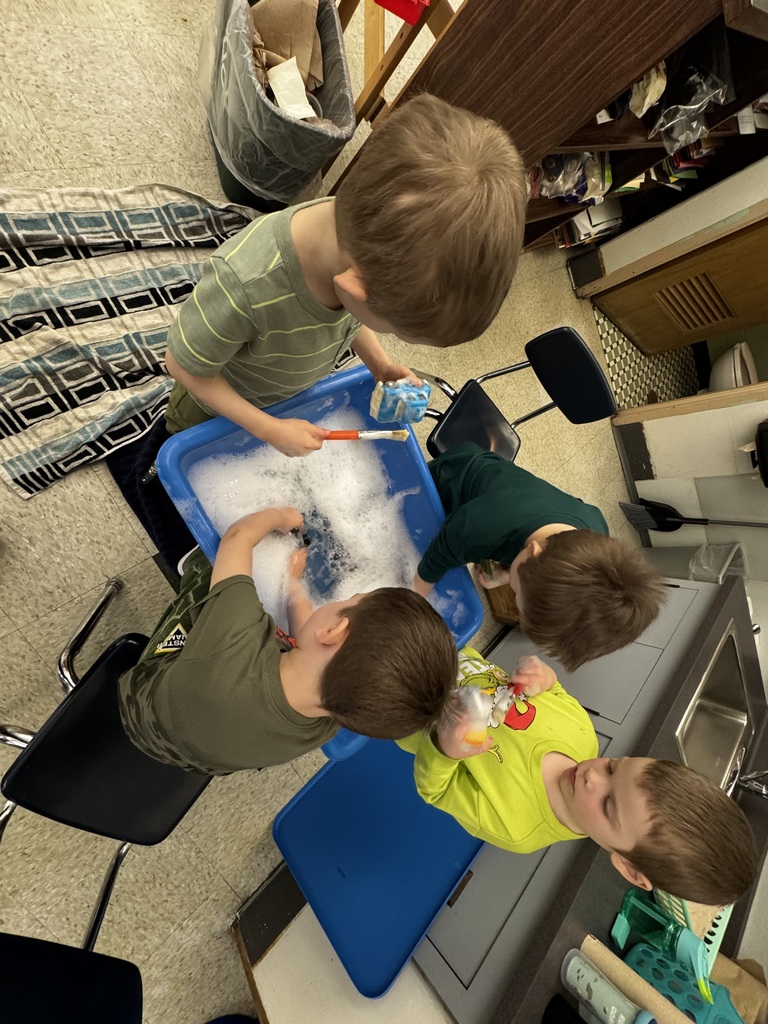 four students washing cars in soapy water