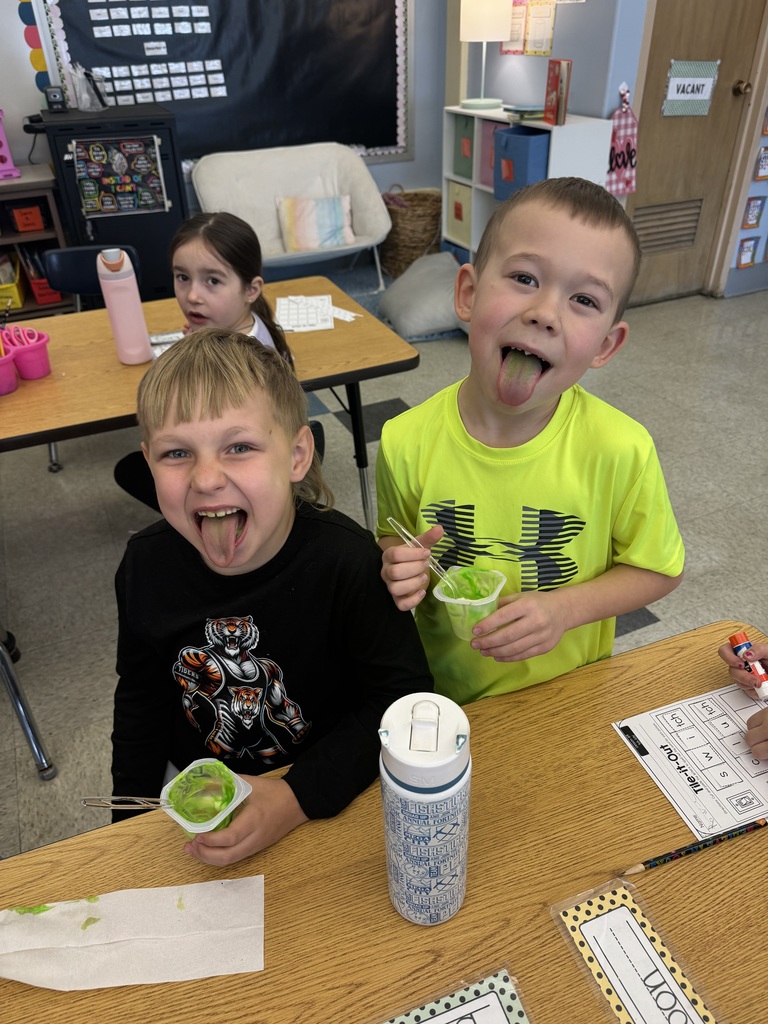 two students with snacks sticking out their tongues