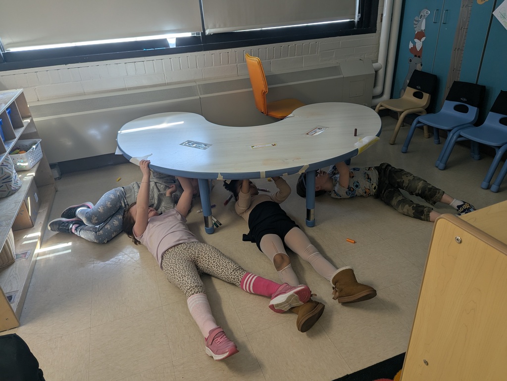 students writing underneath table