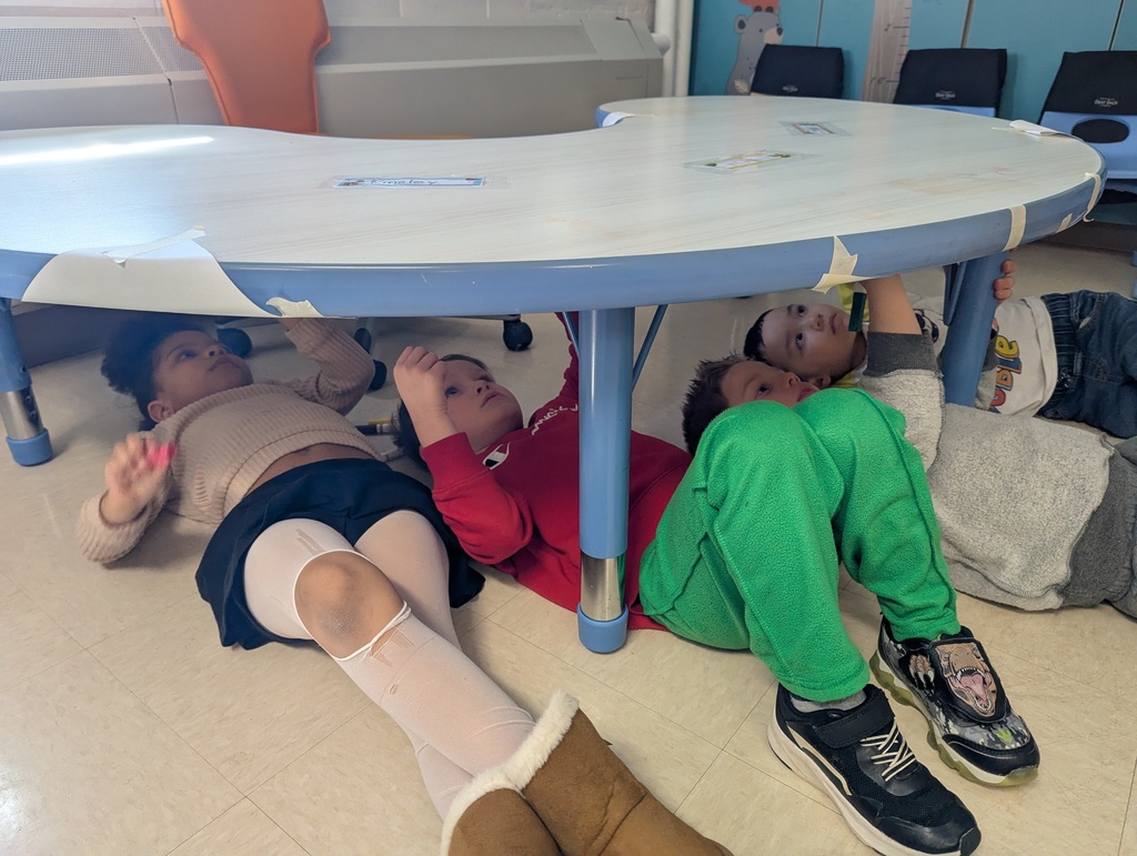students writing underneath table
