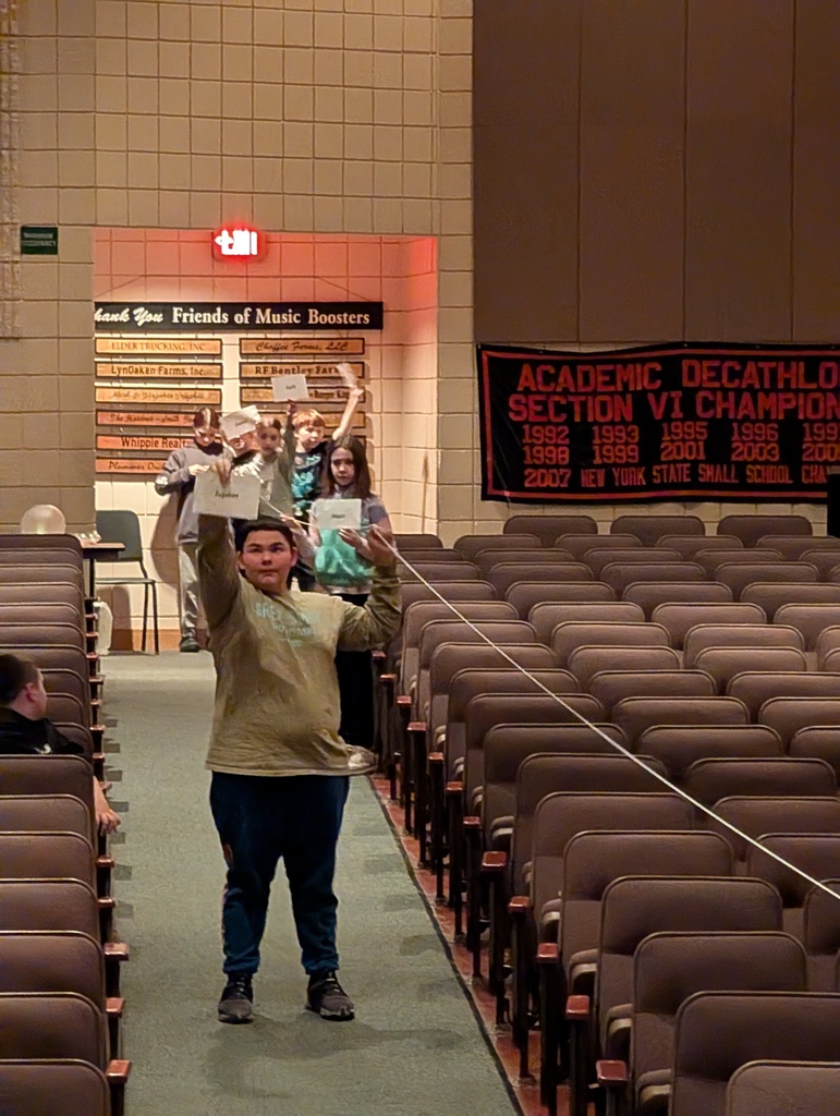 students in auditorium holding up string and paper
