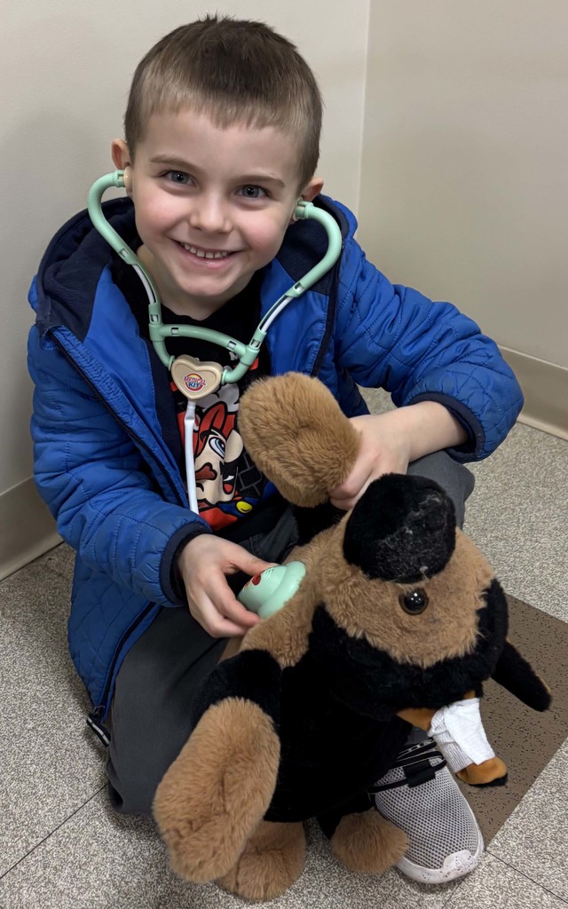boy using stethoscope on stuffed animal
