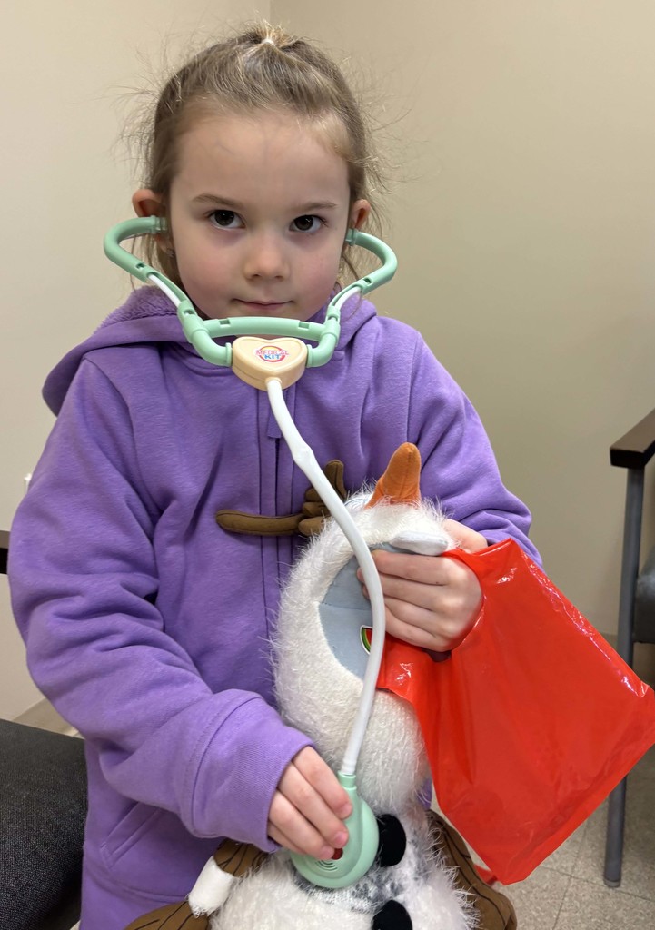 student holding stethoscope on stuffed animal