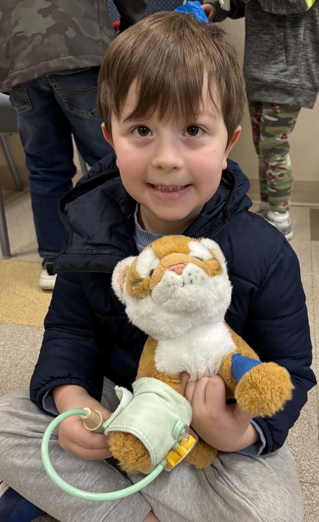 boy holding blood pressure cuff on stuffed animal
