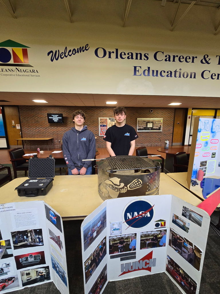 two students behind a booth with displays