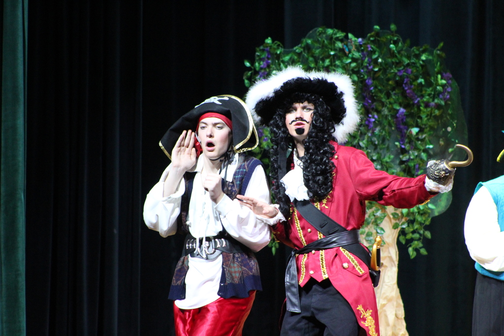 two students in costume on stage
