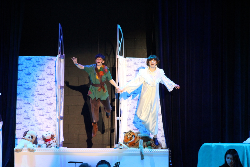 two students flying on stage