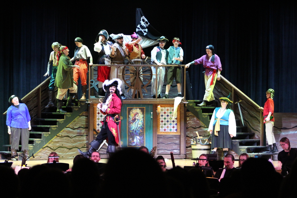 students standing on stage and sets in costume