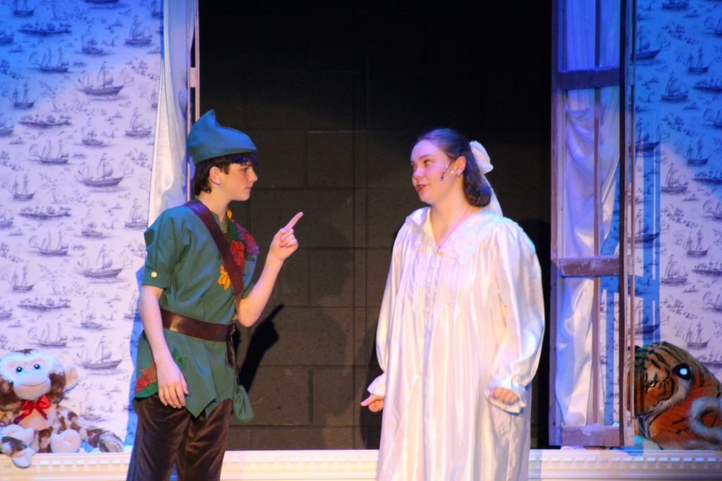 two students dressed in costumes on stage