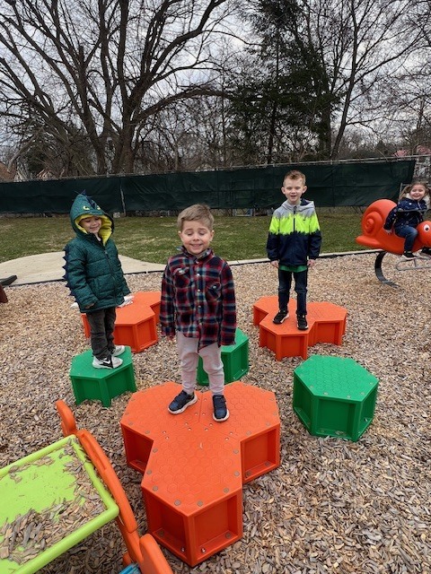 students standing and riding on toys on playground