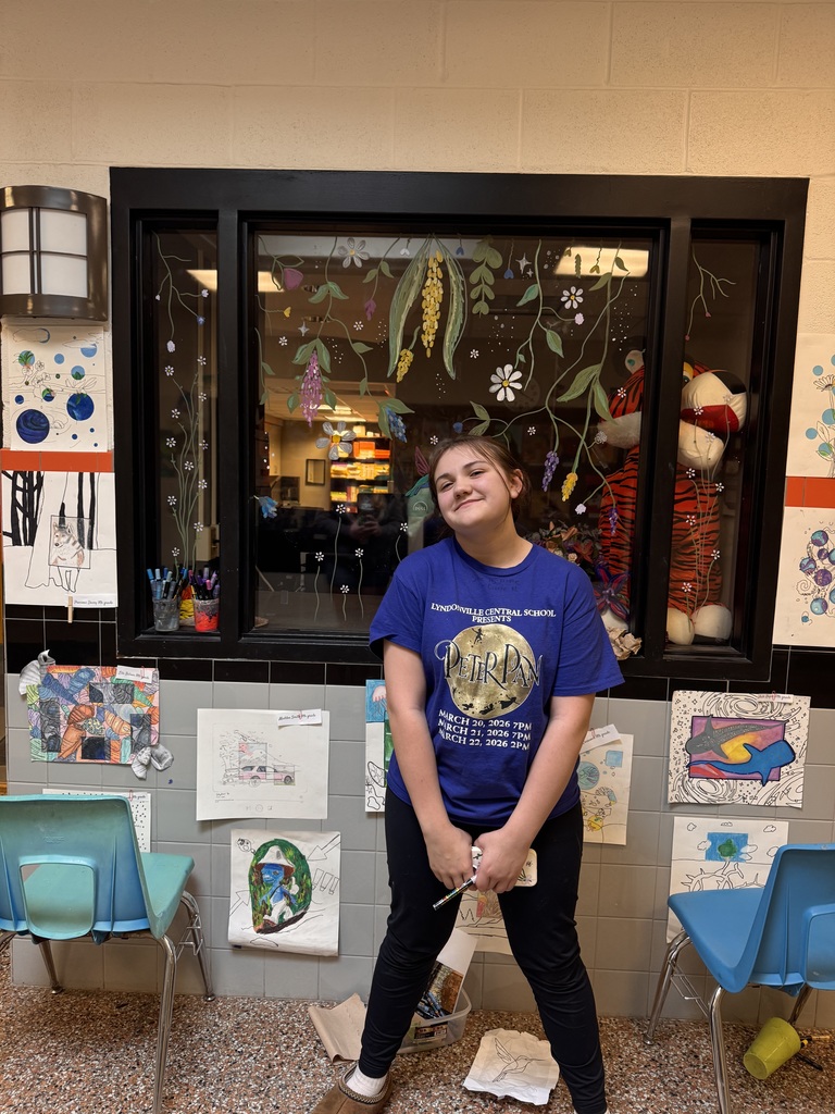 student in front of art display outside main office