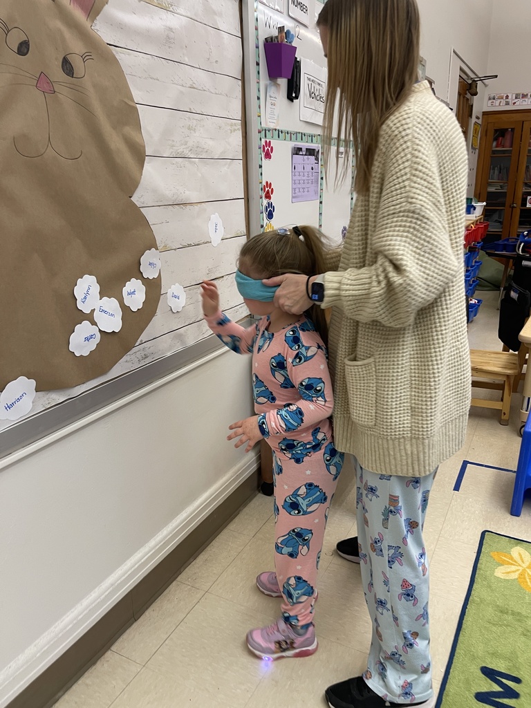 student playing a game blindfolded with teacher near them