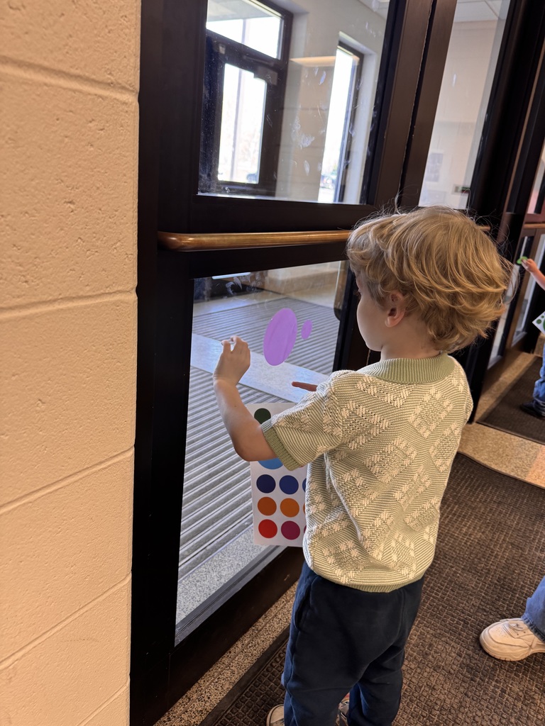 student adding polka dot clings to window