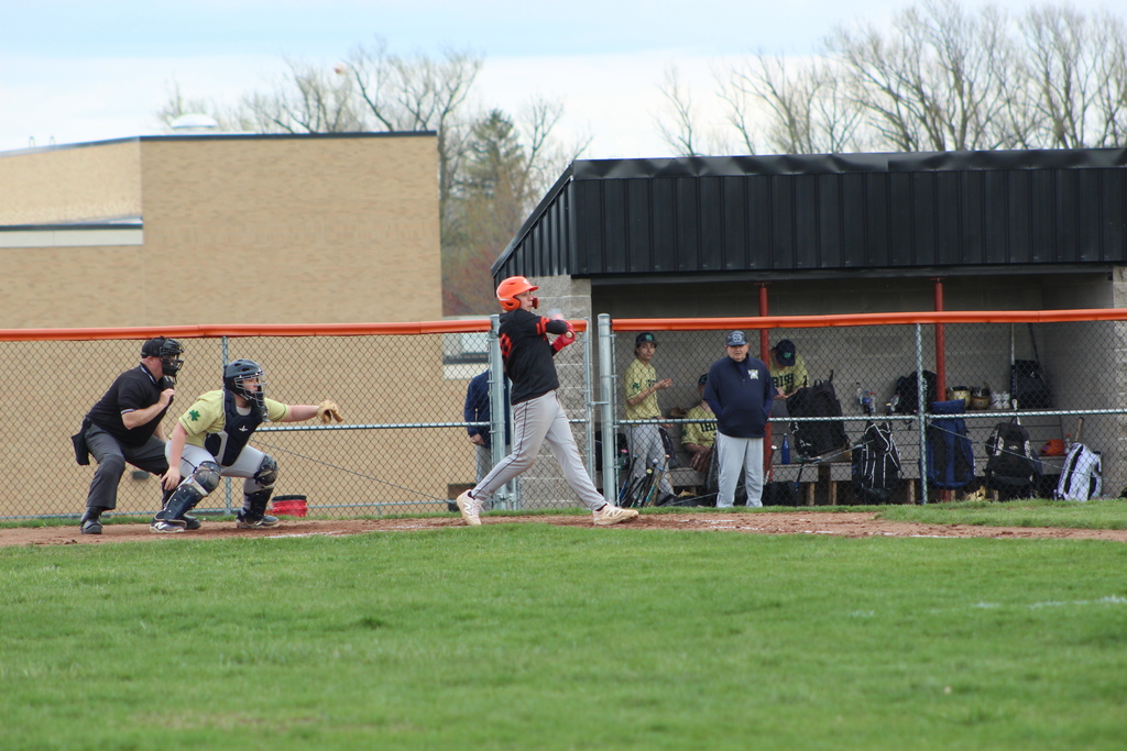 boy hitting ball with bat