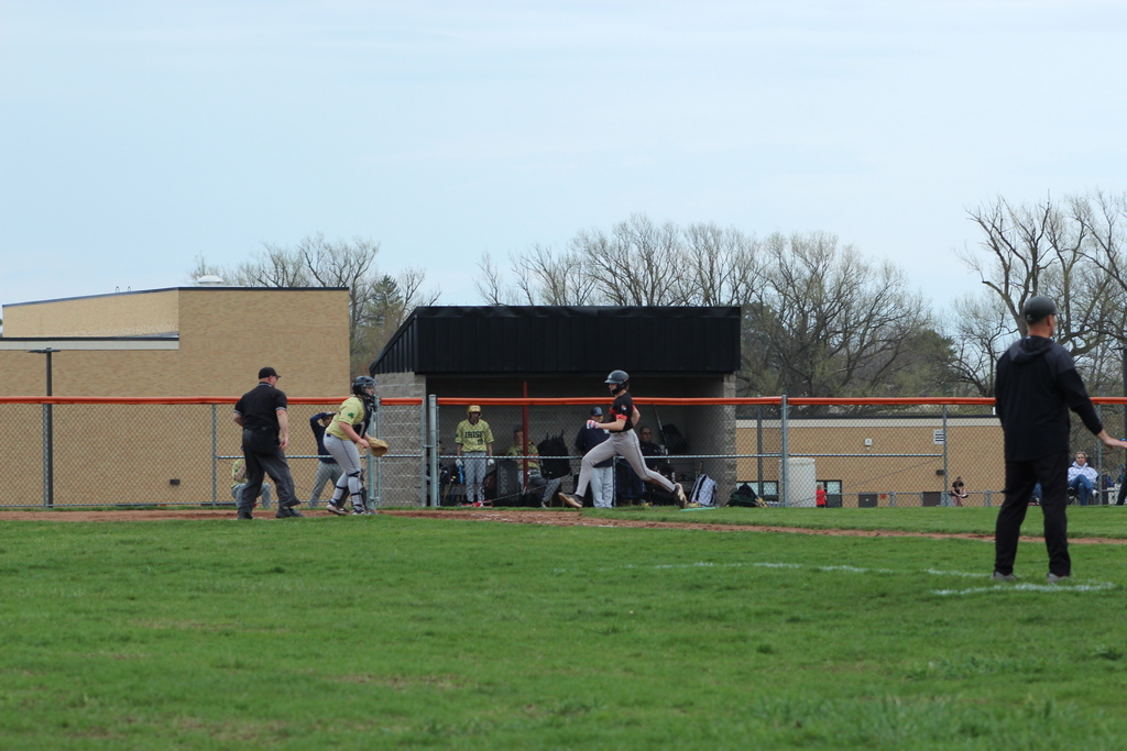 boy running towards home base in baseball game