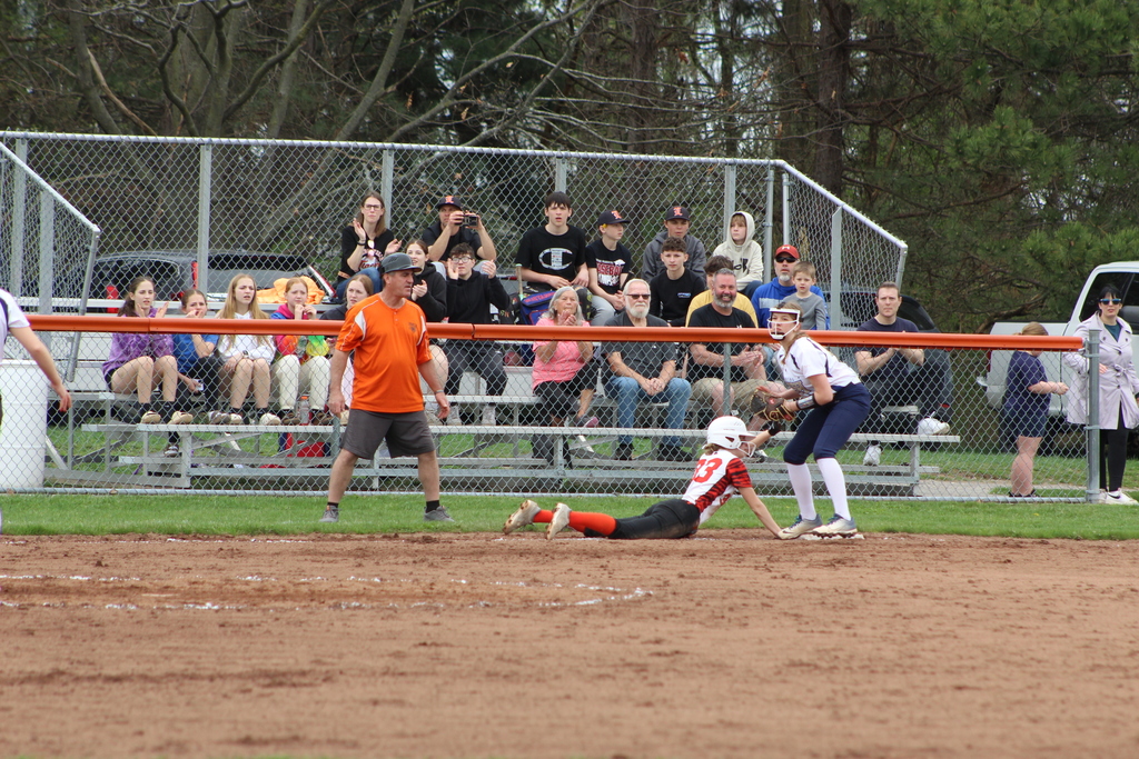 girl sliding into third base in softball game