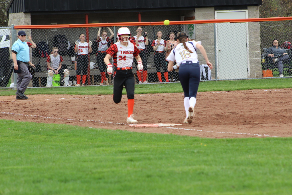 girl running to first base in softball game