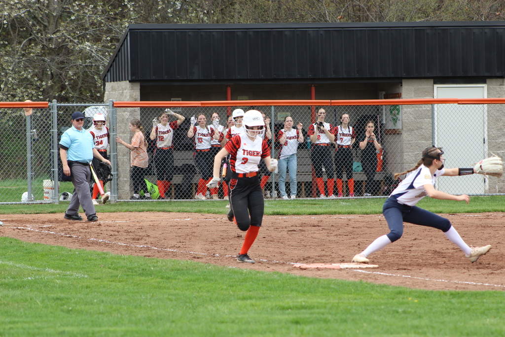 girl running to first base in softball game