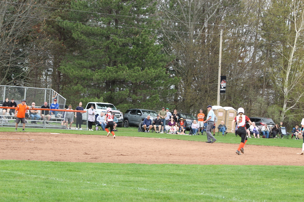 girls running to second and third base in softball game