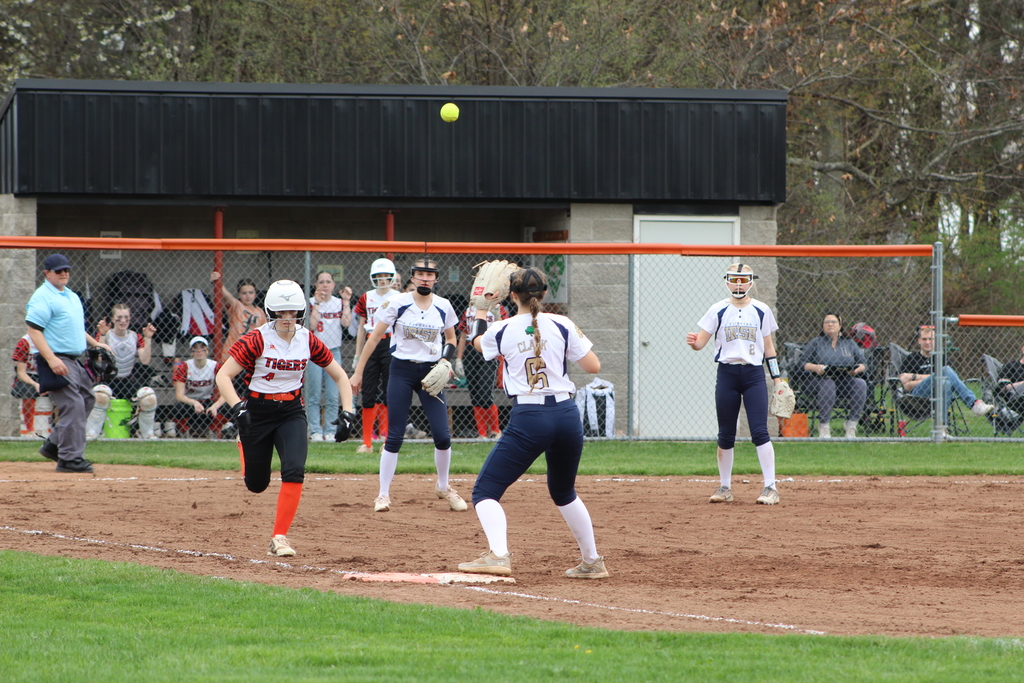 girl running towards first base in softball game