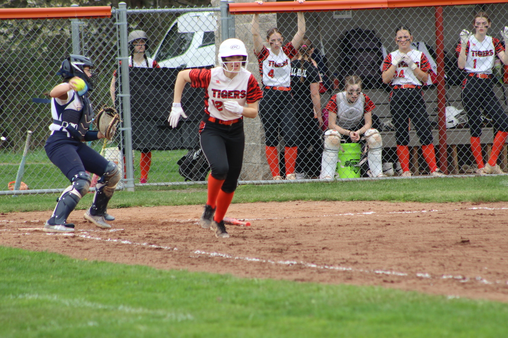 girl running to first base in softball game